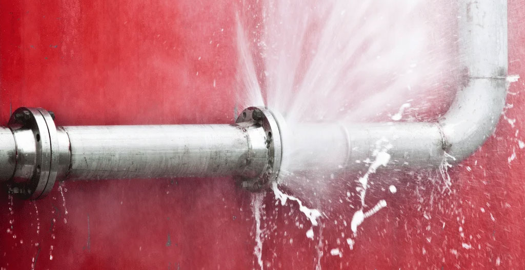 Eau qui s'écoule d'une canalisation endommagée dans un couloir de local commercial